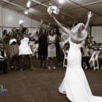 A bride gets ready to throw her bouquet in the Ford Tent.