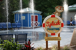 The Splash Fountain sign sitting in front of water spraying up from the Splash Fountain.