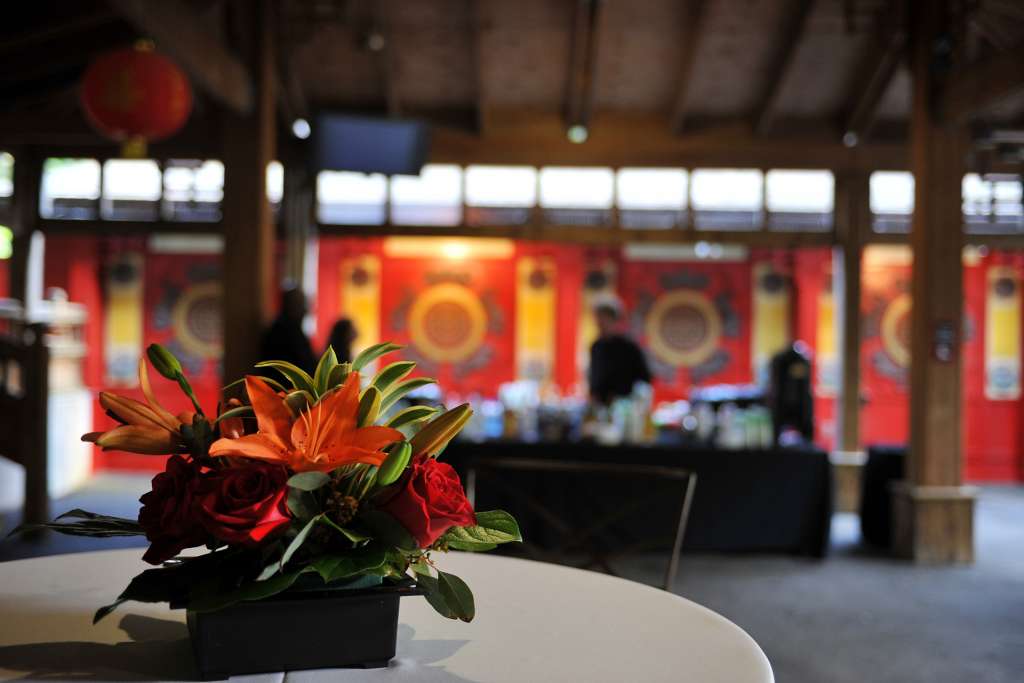 A flower arrangement on a table in front of a bar in the panda veranda.