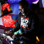 DJ DMark spins tunes on a turntable during an event
