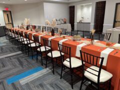 A room with long banquet table set up for an event.