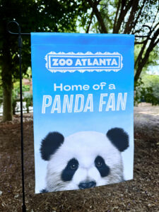 A blue garden flag with a panda face and the text "Home of a PANDA FAN"