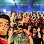 The Geeks band poses at Brew at the Zoo in front of a large party crowd