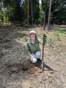 a woman kneels in the rainforest