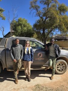 three people post with a truck with a ground hornbill logo