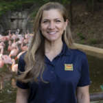 Associate veterinarian Dr. Kate Leach posing in front of the flamingo habitat