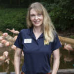 Veterinarian Megan Watson poses in front of the flamingo habitat.