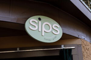 A sign reading "Sips" for the coffee restaurant offering in Zoo Atlanta's Flamingo Plaza.