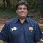 Veterinarian Sam Rivera poses in front of the flamingo habitat.